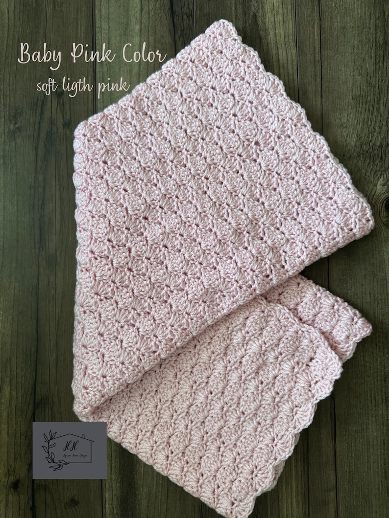 Puede incluir: Una manta de ganchillo rosa claro con un borde festoneado. La manta est&aacute; doblada, mostrando el intrincado patr&oacute;n de puntadas. El texto en la imagen dice "Baby Pink Color, soft light pink."