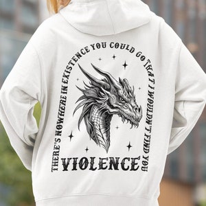Peut inclure: Sweat-shirt blanc avec un motif de dragon noir et blanc et le texte "There's nowhere in existence you could go that I wouldn't find you VIOLENCE".