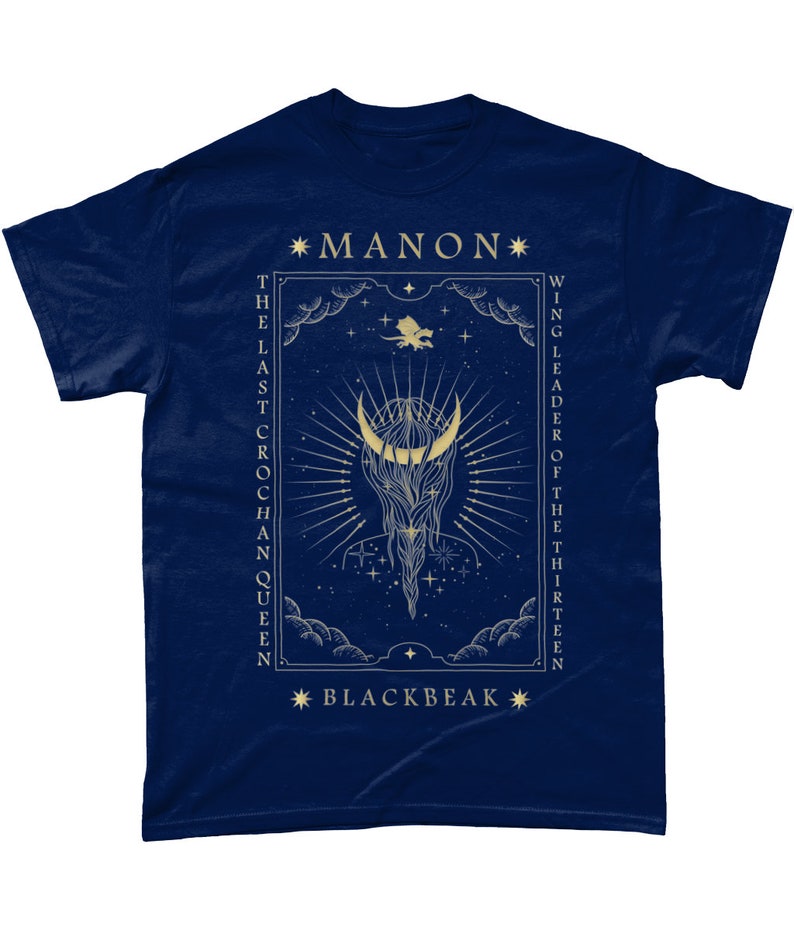 May include: A navy blue t-shirt with a gold design featuring a crescent moon, stars, and a dragon. The text "*MANON* THE LAST CROCHAN QUEEN" and "*BLACKBEAK* WING LEADER OF THE THIRTEEN" is printed on the shirt.