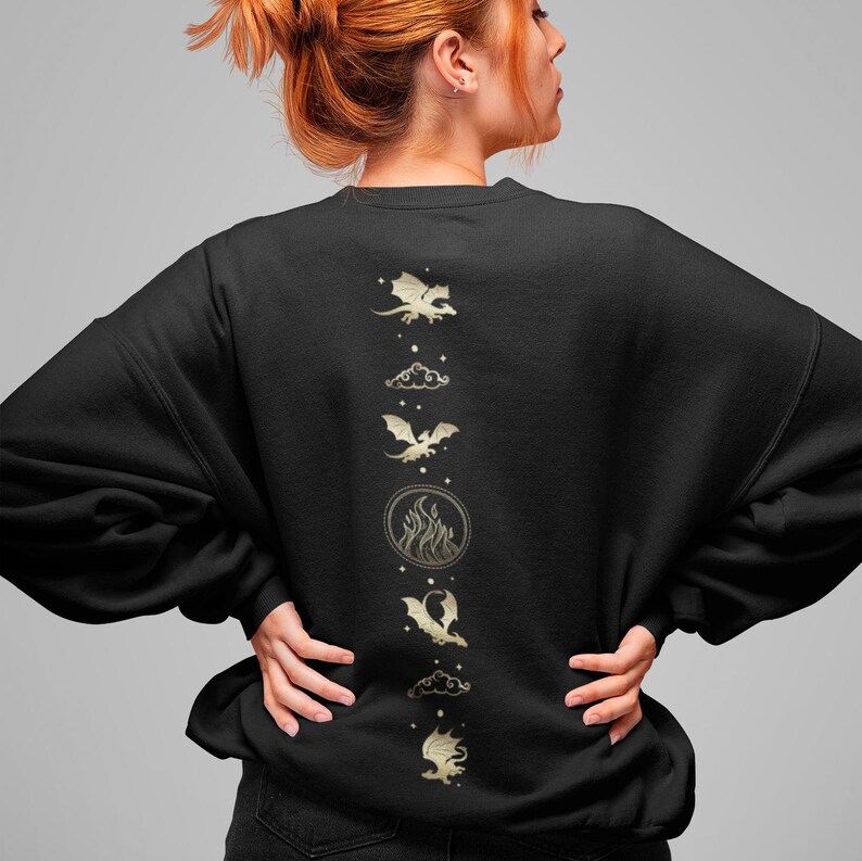 K&ouml;nnte beinhalten: Schwarzer Pullover mit einem goldenen Design aus f&uuml;nf Drachen, die in einer vertikalen Linie fliegen. Die Drachen sind von Wolken und Flammen umgeben.