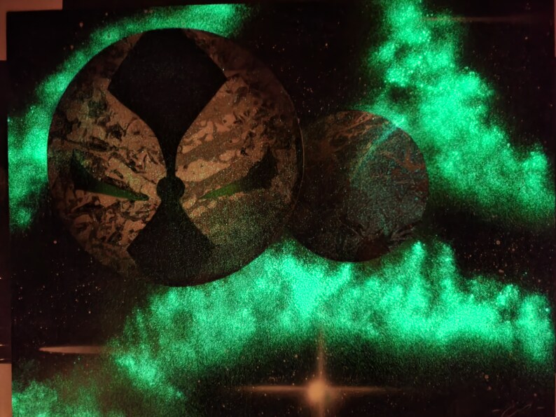 Op de afbeelding: Een abstract schilderij in zwart en groen met een glow-in-the-dark-effect. Het schilderij toont twee grote cirkels met een kleinere cirkel in het midden. De cirkels worden omringd door een groene gloed.