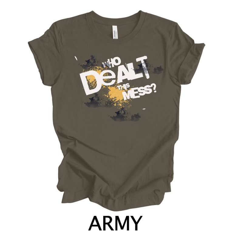 May include: Army green t-shirt with a white graphic that says "Who Dealt This Mess?" The graphic is in a distressed style with a yellow splatter effect.