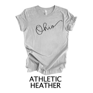 May include: A gray t-shirt with the word "Ohio" written in cursive on the front. The shirt is made of athletic heather fabric.