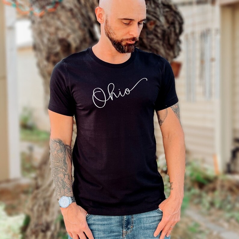 May include: A black t-shirt with a white cursive inscription that reads "Ohio".