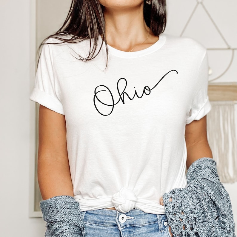 May include: White t-shirt with a black cursive script design that says "Ohio".