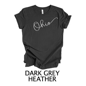 May include: Dark grey heather t-shirt with the word "Ohio" written in white cursive script.