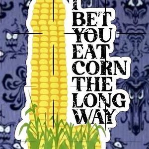 May include: A sticker featuring a yellow corn cob with green stalks and the text "I BET YOU EAT CORN THE LONG WAY" in black. The background is a purple and blue patterned design.