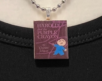 May include: A silver ball chain necklace with a pendant featuring the cover of "Harold and the Purple Crayon" by Crockett Johnson. The pendant is a small, rectangular book cover design with a purple background and a cartoon illustration of a boy.
