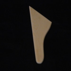 May include: A wooden spatula with a rounded handle and a flat, slightly curved blade.