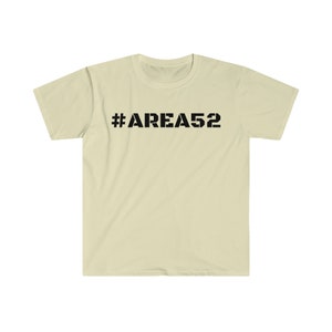 May include: A light beige t-shirt with a black graphic print that says "#AREA52".