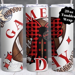 May include: A white 20 oz tumbler wrap with a football design. The design includes the words "GAME DAY" in red, a red and black plaid bow, and a football graphic. The tumbler has a straw and lid.