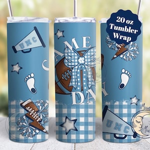 May include: A 20 ounce tumbler wrap featuring a blue and white gingham pattern with a football, a bow, a megaphone, a footprint, and a cheerleader's pom-pom. The text "UNC" and "Game Day" are also included.