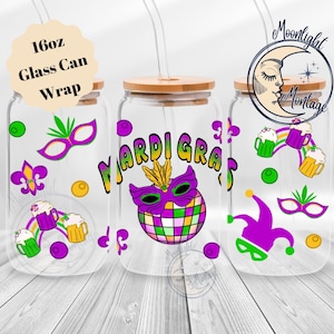 May include: Clear glass can wraps with bamboo lids and straws. The wraps feature Mardi Gras designs, including masks, fleur-de-lis, and the words "Mardi Gras". Each wrap is 16oz.