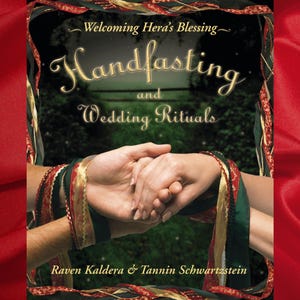 May include: Book cover with the title "Handfasting and Wedding Rituals: Welcoming Hera's Blessing" in gold lettering on a dark green background. Two hands are clasped together, tied with ribbons in red, gold, and green. The authors, Raven Kaldera & Tannin Schwartzstein, are listed below the title.
