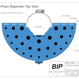 May include: Top view diagram of a blue drill press organizer. The design includes a semi-circular base with multiple circular holes, a central clamp, and dimensional callouts in inches and millimeters. Text includes "Drill Press Organizer Top View" and "Build It Plans".