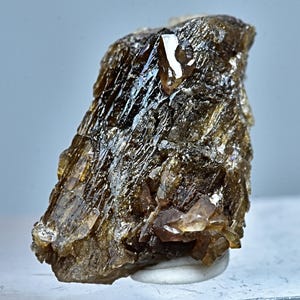 May include: A cluster of brown and clear quartz crystals with a rough, textured surface. The crystals are arranged in a random pattern and have a natural, earthy appearance.