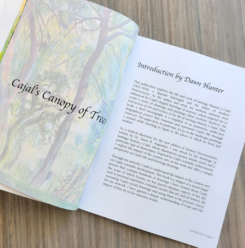 This is an image of the monograph Cajal's Canopy of Trees opened to the title page and introduction by renowned artist and Fulbright Scholar Dawn Hunter.