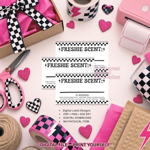 May include: Three white rectangular labels with black checkered borders and the text FRESHIE SCENT: featuring lightning bolt icons. The labels include warning text about keeping away from children and pets. The design is presented with pink hearts, checkered tape, scissors, and packaging materials.