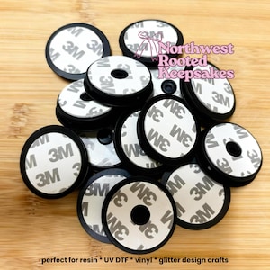 May include: A pile of black circular phone grips with white adhesive pads, marked with "3M". The image includes the text "Northwest Rooted Keepsakes" and "perfect for resin * UV DTF * vinyl * glitter design crafts".