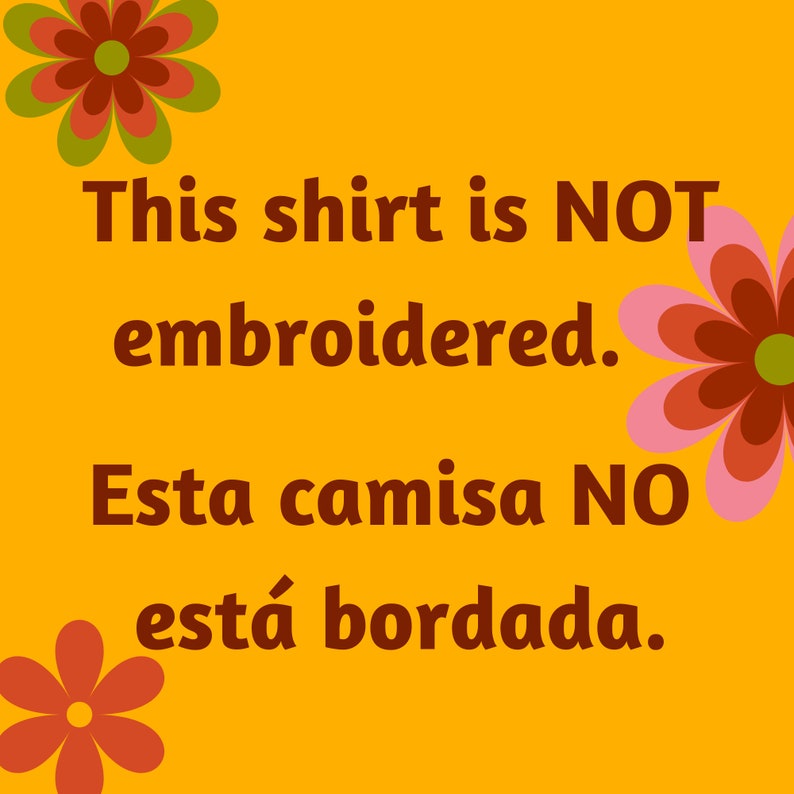 May include: A yellow background with a red and green flower on the top left and a pink and red flower on the right. The text "This shirt is NOT embroidered. Esta camisa NO est&aacute; bordada." is written in brown text.