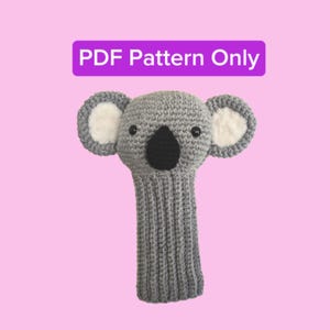 May include: A gray crocheted koala golf club head cover with white ear accents and a black nose. The text "PDF Pattern Only" is in a purple rectangle above the koala. The cover is designed to protect golf clubs.