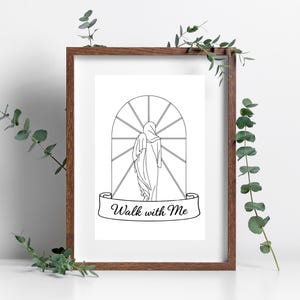 May include: A framed black and white line art print. The artwork depicts a figure walking towards a window with a banner that reads "Walk with Me". The frame is brown, and the background is white. Greenery is placed around the frame.