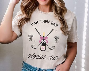 May include: A white t-shirt with the text "Par Then Bar Social Club" printed on it. The design features a pink bow, two golf clubs, and two champagne glasses.