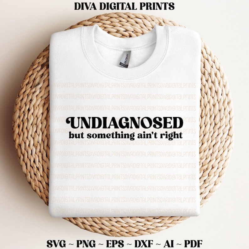 May include: White sweatshirt with the text "UNDIAGNOSED but something ain't right" in black retro-style lettering.