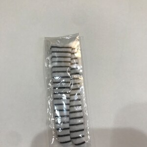 May include: Two pairs of white and black striped socks in a clear plastic bag.