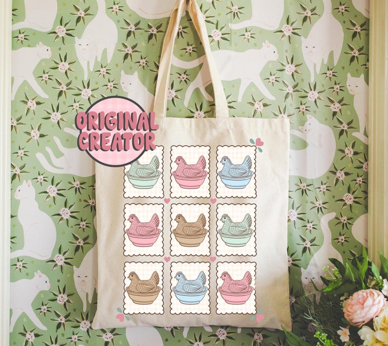 May include: A cream-colored tote bag featuring a repeating pattern of postage stamp-style illustrations of chickens in pastel-colored bowls. The text "ORIGINAL CREATOR" is in a pink circle. The bag has a simple design with long handles.