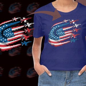 Könnte beinhalten: Ein marineblaues T-Shirt mit einer Grafik der amerikanischen Flagge und Düsenjets. Das Flaggen-Design enthält Sterne und Streifen, mit Düsenjets in Rot, Weiß und Blau. Das T-Shirt hat einen Rundhalsausschnitt.