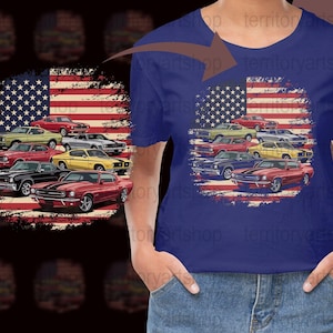 May include: A blue t-shirt with a distressed American flag design featuring a line of classic muscle cars. The cars are red, yellow, and blue, and the flag is faded and worn.