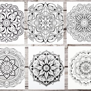 May include: Six black and white mandala designs on a wood background. Each mandala is intricate and detailed, featuring a variety of geometric shapes and patterns.