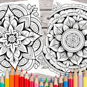 May include: Two black and white mandala coloring pages with intricate designs. The mandalas feature floral patterns and geometric shapes. The pages are surrounded by a set of colored pencils.