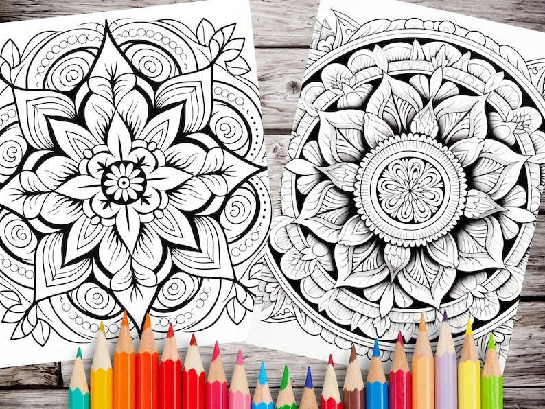 May include: Two black and white mandala coloring pages with intricate designs. The mandalas feature floral patterns and geometric shapes. The pages are surrounded by a set of colored pencils.