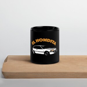 May include: Black ceramic mug featuring a white Honda Civic illustration and the text "EL HONDITA" in orange.