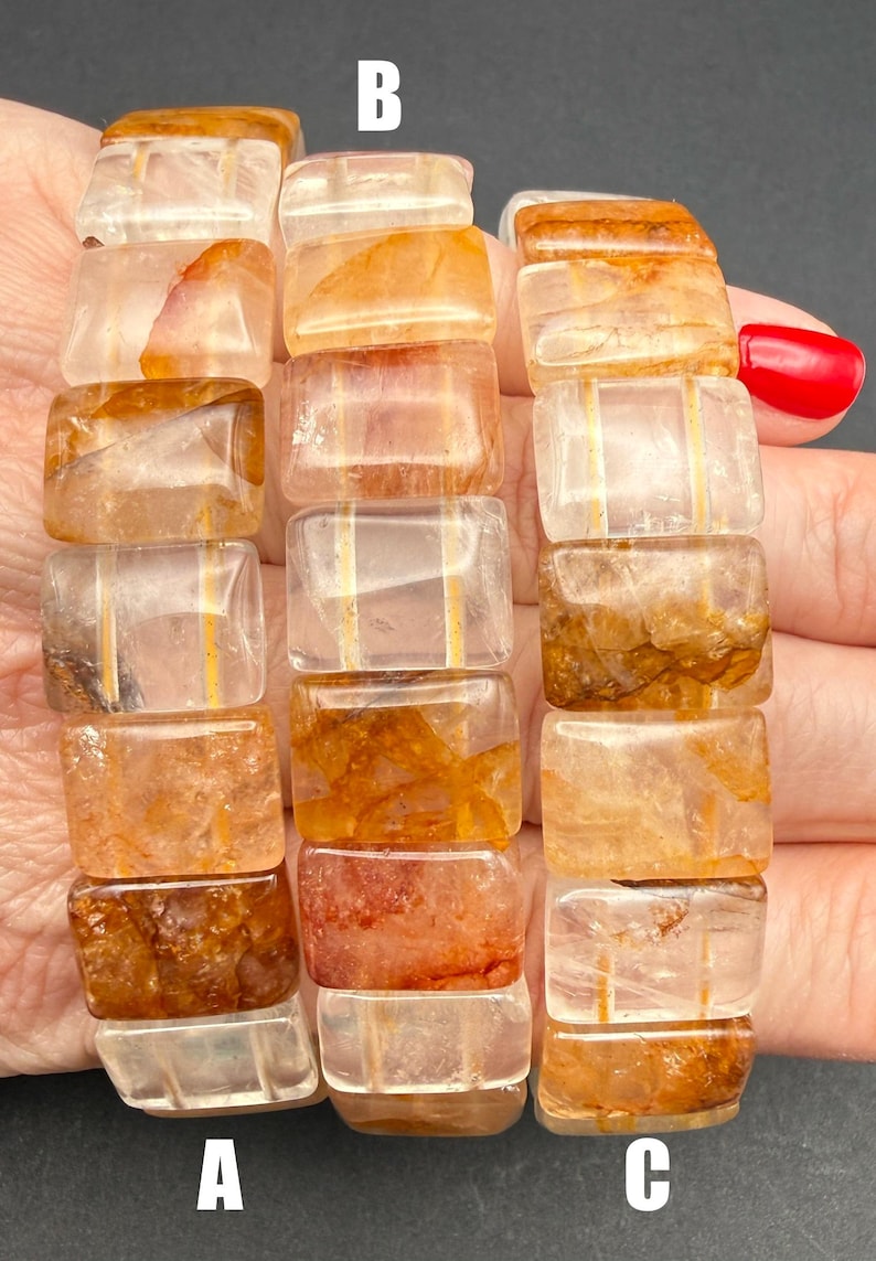 May include: Three bracelets made of rectangular, translucent beads with orange and brown inclusions. The beads are strung together, forming a flexible band. The bracelets are held in a hand, with the letters A, B, and C visible.