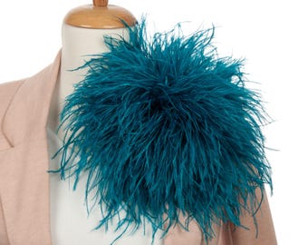 May include: Teal blue ostrich feather boa. The boa is fluffy and full, and would be a great addition to any costume or outfit.