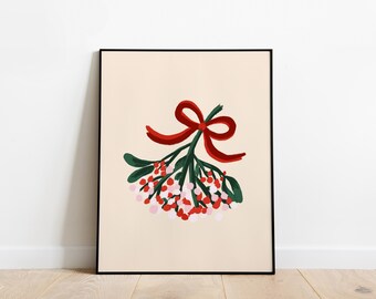 May include: A framed wall art print featuring a centered illustration of a mistletoe sprig with dark green leaves and clusters of red and light pink berries, tied together with a bright red ribbon bow against a solid light beige background.