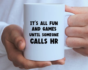 May include: White ceramic coffee mug with black text that reads "It's all fun and games until someone calls HR".