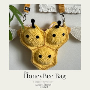 May include: A crocheted honeybee bag with a yellow and brown honeycomb design. The bag has a strap and is decorated with black eyes and antennae.