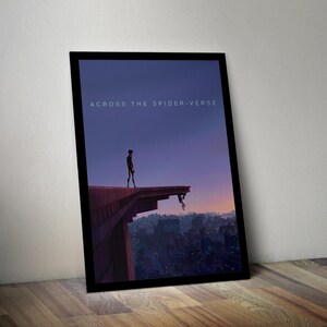May include: A black framed poster with the text "Across the Spider-Verse" in white. The poster features a silhouette of two figures standing on a rooftop overlooking a city skyline.
