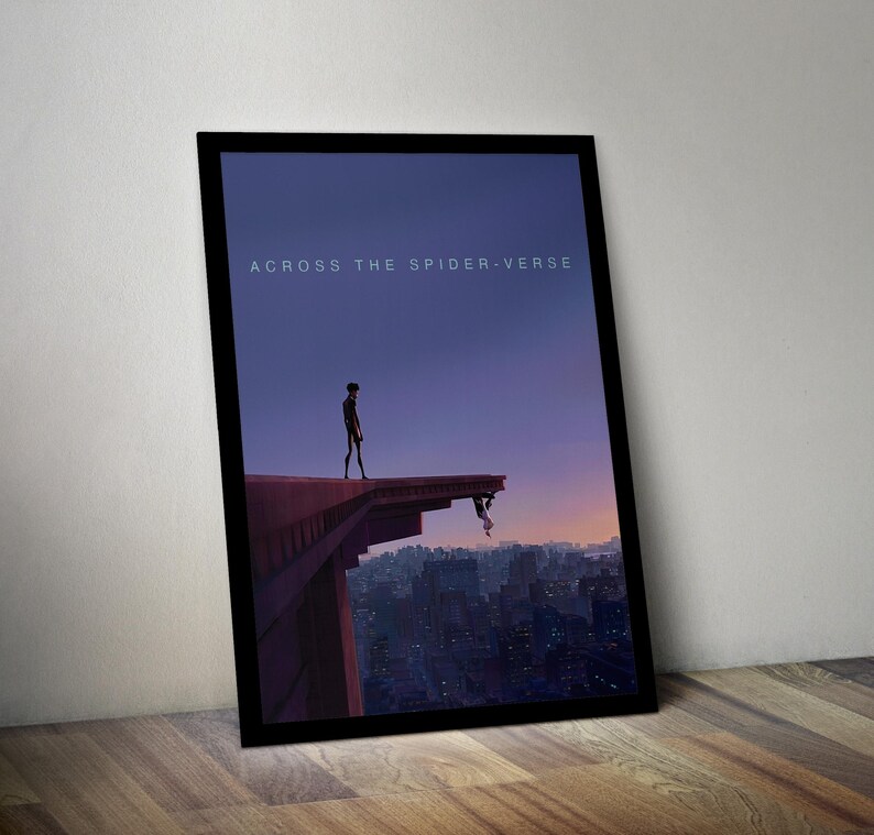 May include: A black framed poster with the text "Across the Spider-Verse" in white. The poster features a silhouette of two figures standing on a rooftop overlooking a city skyline.