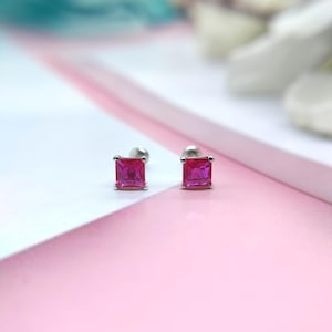 Pode incluir: Um par de brincos de prata com pedras quadradas cor-de-rosa.