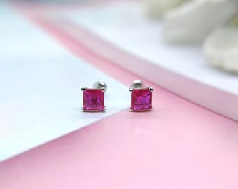 以下が含まれることがあります： 正方形のピンクの宝石が付いたシルバーのスタッドピアスのペア