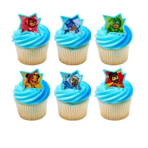 May include: Six blue and white cupcakes with edible toppers featuring characters from the children's television show, PJ Masks. The toppers are in the shape of a star and feature the characters Gekko, Owlette, Catboy, Amaya, Connor, and Greg.