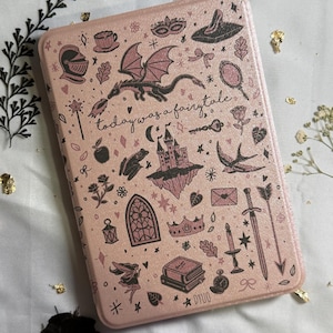 Może przedstawiać: Różowe, prostokątne etui z motywem baśniowym. Etui zawiera ilustracje smoka, zamku, miecza i innych elementów fantasy. Widoczny jest również tekst "today was a fairytale".