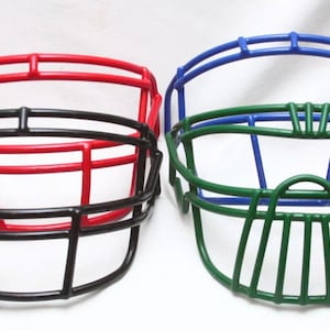 May include: Three football face masks in different colours: red, black, and green. The masks are made of metal and have a traditional design.