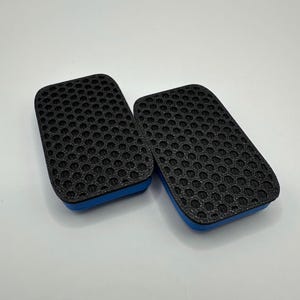 May include: Two black rectangular air filters with a blue trim. The filters have a honeycomb pattern.
