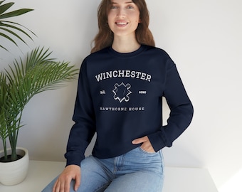 May include: A navy blue sweatshirt with a white graphic of the Winchester logo, which includes the text "Winchester", "Hawthorne House", "S.D.", and "R.D.", and a stylized star.